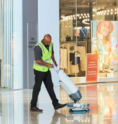 Cleaner wearing high vis in a shopping centre