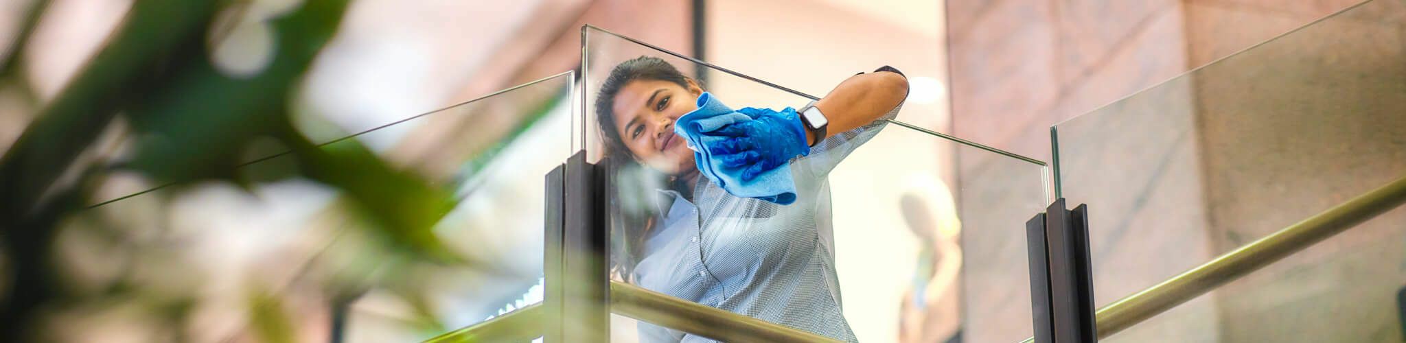 Team member cleaning a commercial glass balustrade