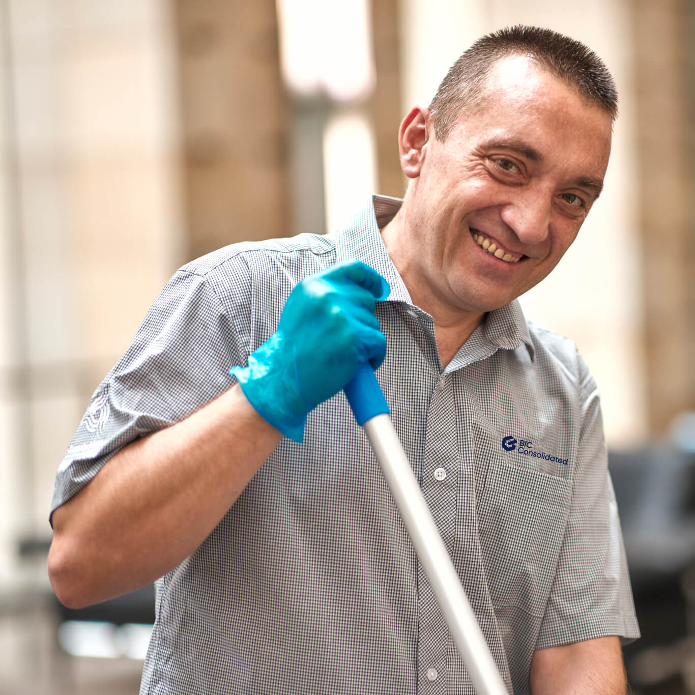 A male cleaner holding a mop